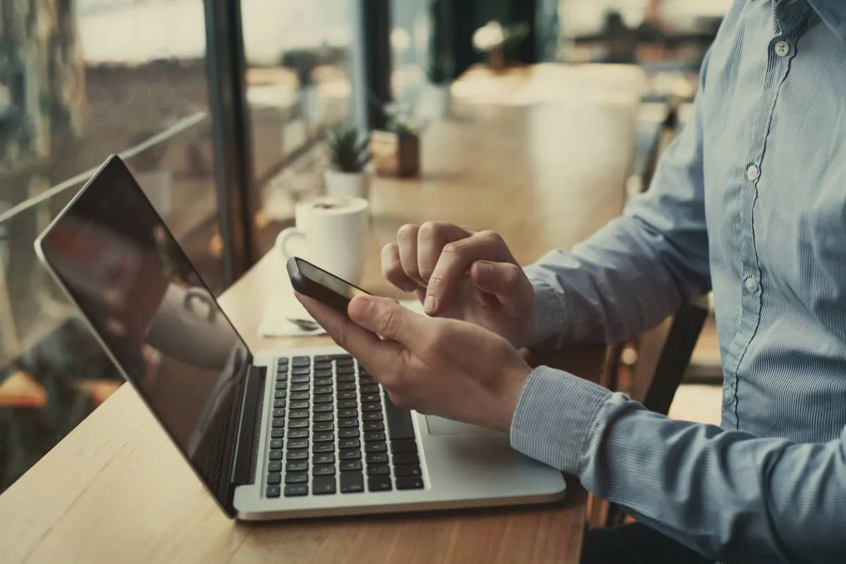 Un homme consulte son espace de gestion de copropriété en ligne sur son téléphone