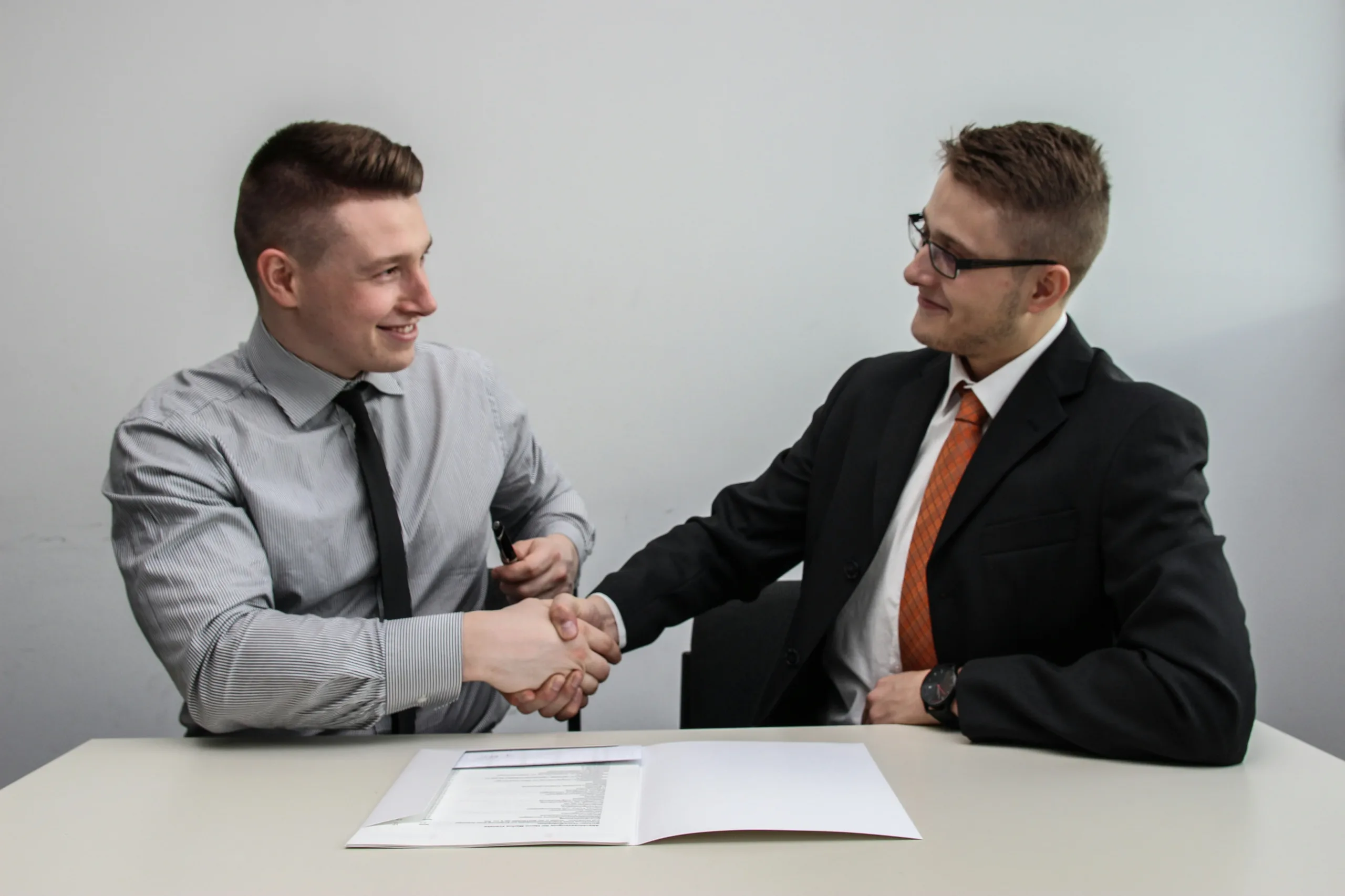 Deux hommes se serrant la main après la signature d’un contrat d’assurance habitation