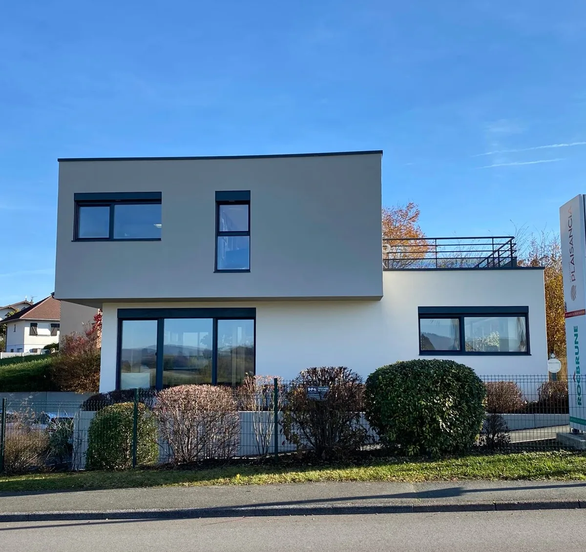 Maison contemporaine à l’architecture cubique et épurée, située dans un quartier résidentiel calme et verdoyant